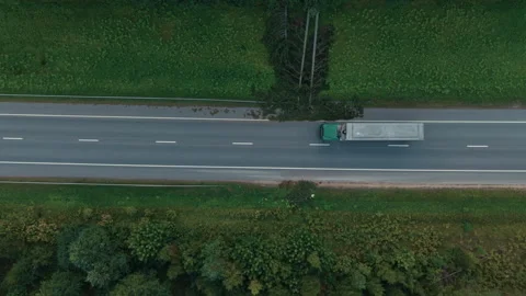 Top view of rural highway crossing dense green forest with lone truck on road Stock Footage 345529683