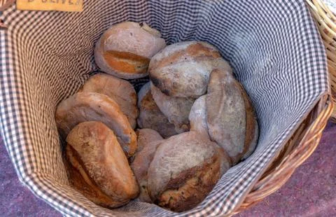 Top view on rustic bread in a wooden wicker basket on a natural linen napkin Stock Photos