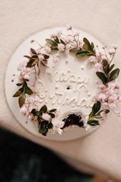 Top view of rustic style white cream cake decorated with fresh flowers, green Stock Photos