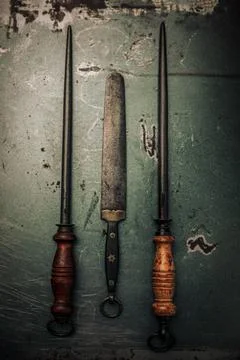 Top view of rusty decayed knife sharpeners on vintage metallic background Stock-Fotos