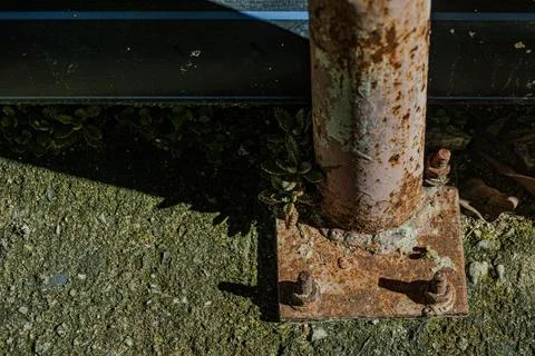 Top view of rusty iron pillar base with bolts and plants near midnight Stock Photos
