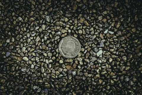 A top view of rusty old and worn out coins placed on the ground with tiny sto Foto stock