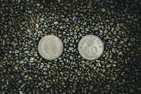 A top view of rusty old and worn out coins placed on the ground with tiny sto Foto stock