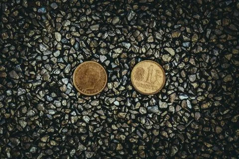 A top view of rusty old and worn out coins placed on the ground with tiny sto Foto stock
