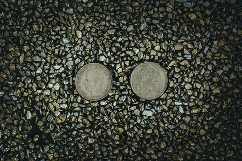 A top view of rusty old and worn out coins placed on the ground with tiny sto Foto stock