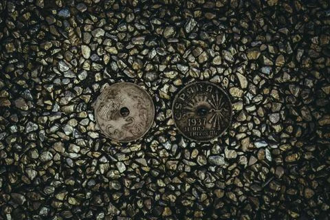 A top view of rusty old and worn out coins placed on the ground with tiny sto Foto stock