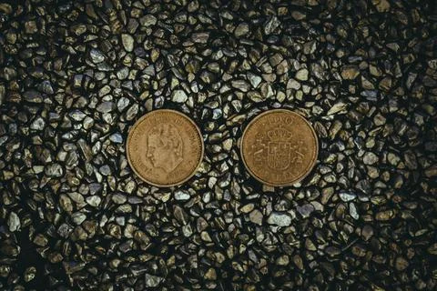 A top view of rusty old and worn out coins placed on the ground with tiny sto Foto stock