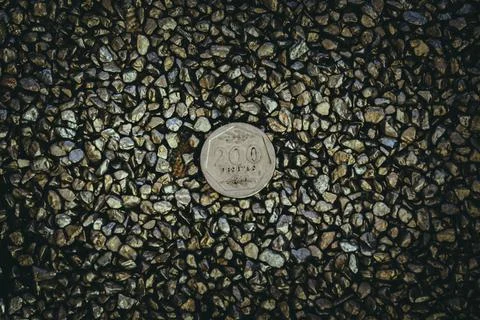 A top view of rusty old and worn out coins placed on the ground with tiny sto Foto stock