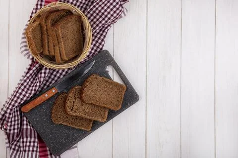Top view of rye bread slices with knife on cutting board and in basket on p.. Foto stock