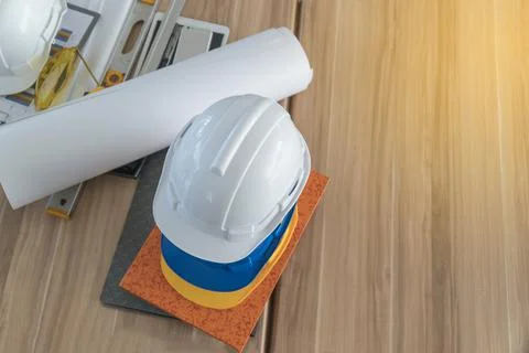 Top view of a safety hat on the table with a roll of paper and accessories on Stock Photos