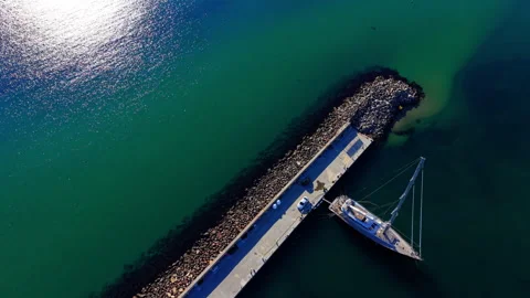 Top view of sailboat docked at stone pier Stock Footage 327929800