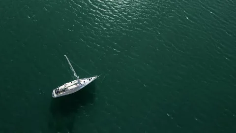Top view of a sailboat gliding smoothly across the deep blue water, showcasing Stock-Footage 332455422