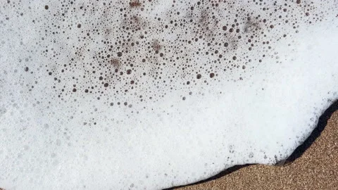 Top view of sand and water foam waves coming in and out Stock Footage 233209986