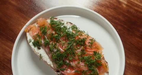 Top view on Sandwich with red fish. The chef rotation the plate in camera on Stock Footage 319399875