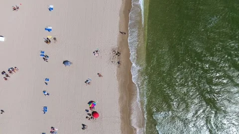 Top view of sandy beach with people, umbrellas and ocean capturing serene Video stock 274285848