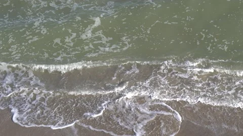 Top view of a sandy beach, sea waves crashing on the shore, sea foam Stock Footage 164851190