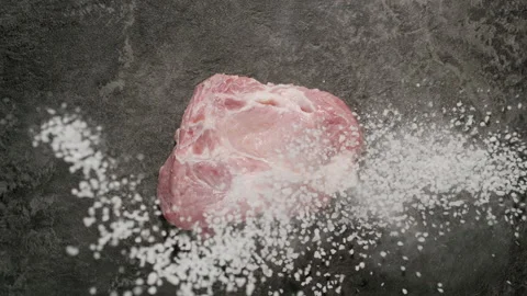 TOP VIEW: Sea salt fall on pork steak,  Slow motion Stock Footage 144416330