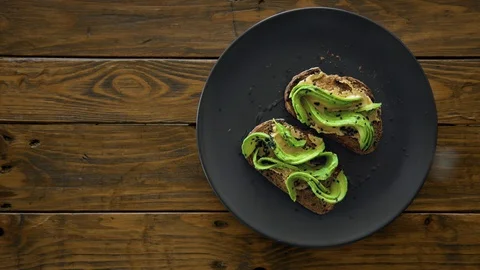 Top view on sea salt sprinkle on avocado toast 스톡 동영상 127966932