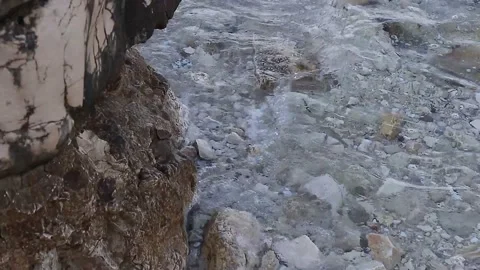 Top view of the sea surface with small waves hitting the rock Stock Footage 138740343