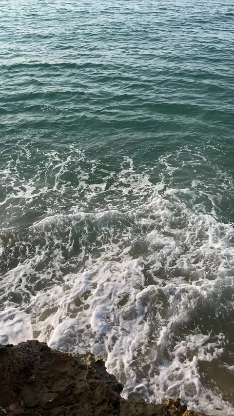 Top view of sea waves crashing against rocky cliffs Stock Footage 344412722
