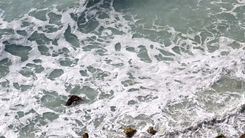 Top view of sea waves hitting rock shore. Tilting movement of camera Stock Footage 104101156