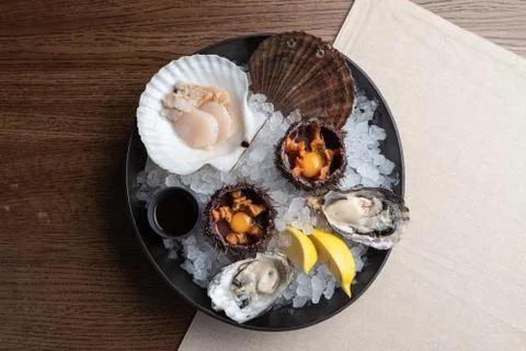 Top view of seafood platter: shellfish, oysters, sea urchin and balsamic sauc Stock Photos