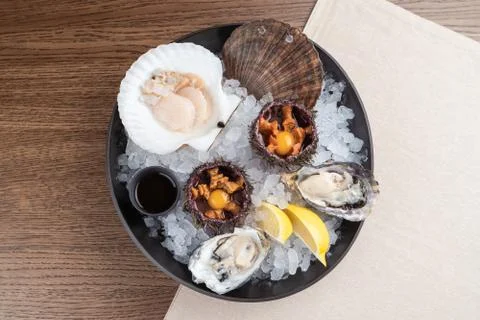 Top view of seafood platter: shellfish, oysters, sea urchin and balsamic sauc Stock Photos