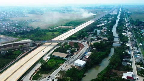 Top view seeing a long road and a small town beside the Bekasi river Indonesia Stock Footage 213213442