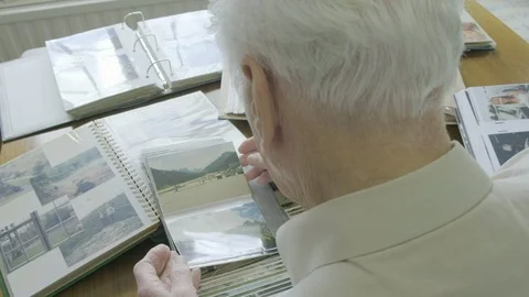 Top view of a senior man looking through old photo albums Stock Footage 104584053
