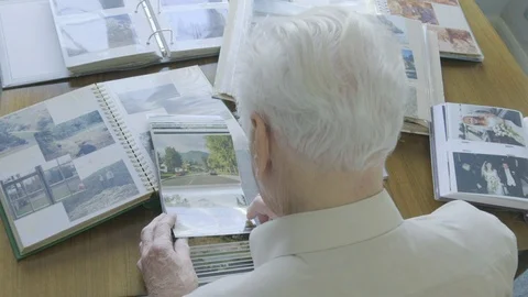 Top view of a senior man looking through old photo albums Video stock 104584579