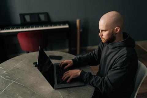 Top view of serious skilled programmer with beard and hoodie working typing on Stock Photos