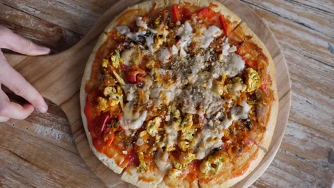 Top view of serving vegan pizza on the wooden tray at the wooden table. Ideas Video stock 147573915