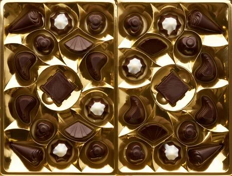 Top view of several assorted chocolates in a yellow packing box Stock Photos
