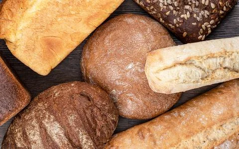 Top view of several loaves of bread over a wooden background. Stock Photos