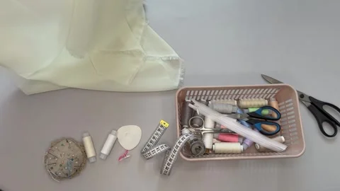 Top view of sewing accessories. White silk fabric falling on cutting table Stock Footage 306561080