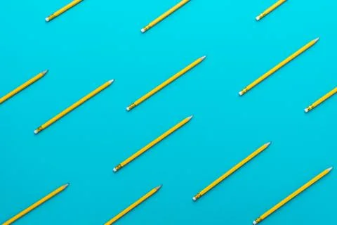 Top view of sharpened simple yellow pencils over turquoise blue background Stock Photos