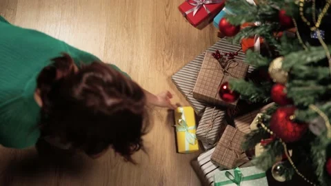 Top view. She puts small gift wrapped in yellow paper tied with white ribbon Video stock 163451435