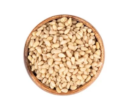 Top view of shelled pine nuts in a wooden bowl. Stock Photos