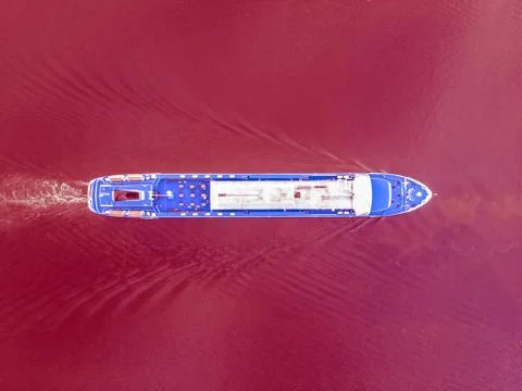 Top view of a ship sailing along the red surface Stock Photos