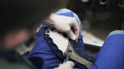 Top view of shoemaker nailing a shoe and looking at result Stock Footage 75942163