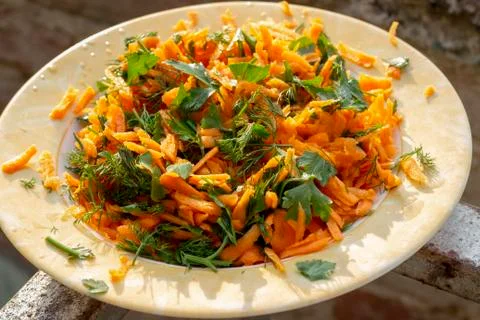 Top view shoot of fresh looking carrot salad on plate under beautiful sunligh Stock Photos