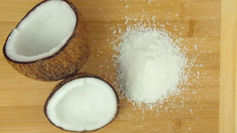 Top view shot of falling dried white coconut flakes on a wooden platform Video stock 130839800