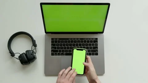 Top View Shot Of Green Screen Laptop, Smartphone And headphones, hdd disc On A Stock Footage 237625487