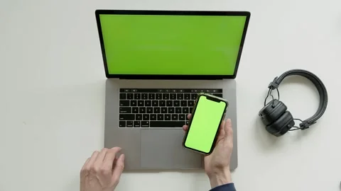 Top View Shot Of Green Screen Laptop, Smartphone And headphones, hdd disc On A Stock Footage 243645857