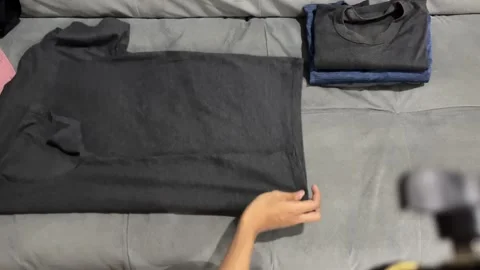 Top view shot of hands folding washed t-shirts Stock Footage 347012090