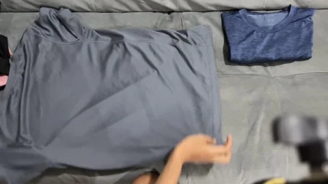 Top view shot of hands folding washed t-shirts Stock Footage 347012092