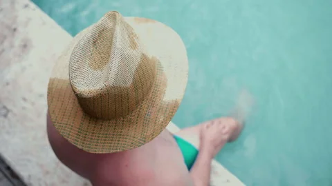 Top view shot of man in straw hat sitting on pool side and enjoying amazing Stock-Footage 296803756