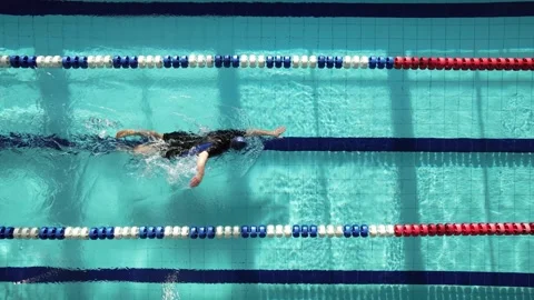 Top view shot of young man swimming laps in a swimming pool. Male swimmer swimmi Stock Footage 236700960