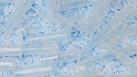 Top view shows clear microtubes and polymer granules rotating together for Stock Footage 347049618