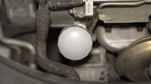 Top view of a silver metal spin-on oil filter installed in a car engine bay. Stock Footage 342260659